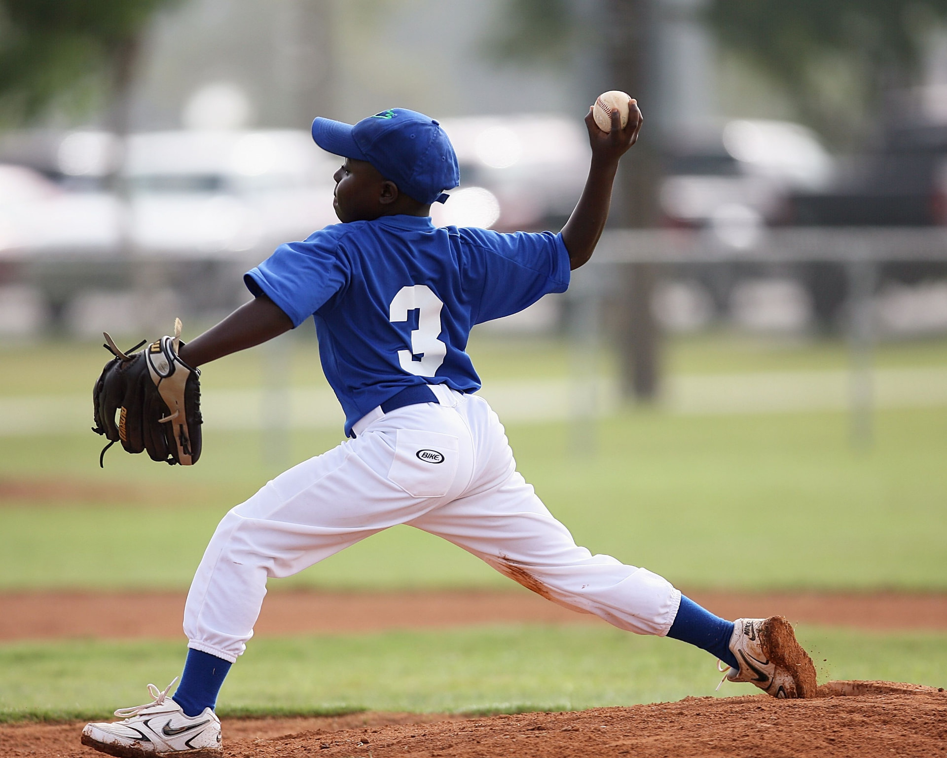Youth baseball pitcher delivering a pitch from the mound during a game